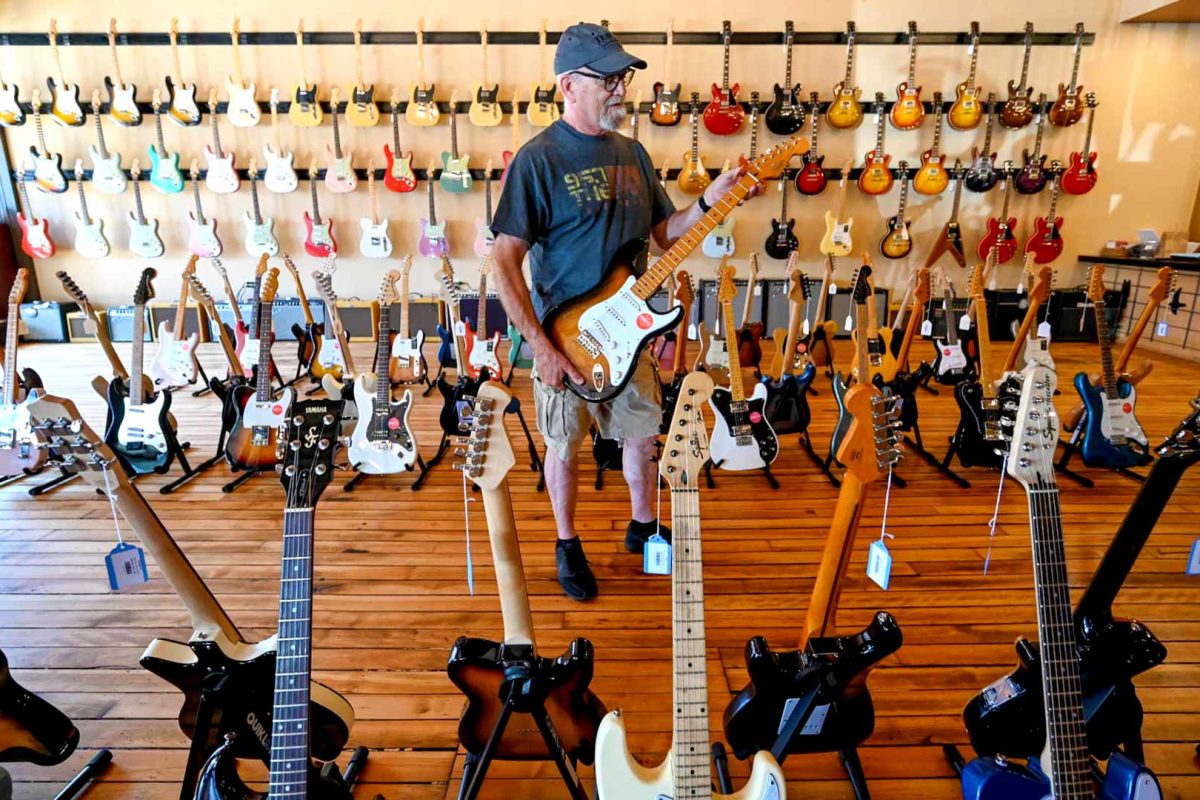 Your guide to shopping in downtown Marshfield | Man playing guitar at Dave’s Guitar Shop downtown Marshfield WI