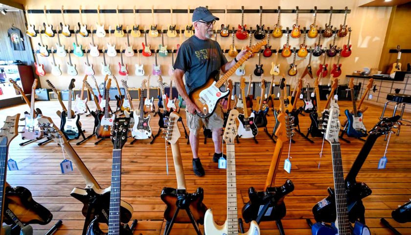 Your guide to shopping in downtown Marshfield | Man playing guitar at Dave’s Guitar Shop downtown Marshfield WI