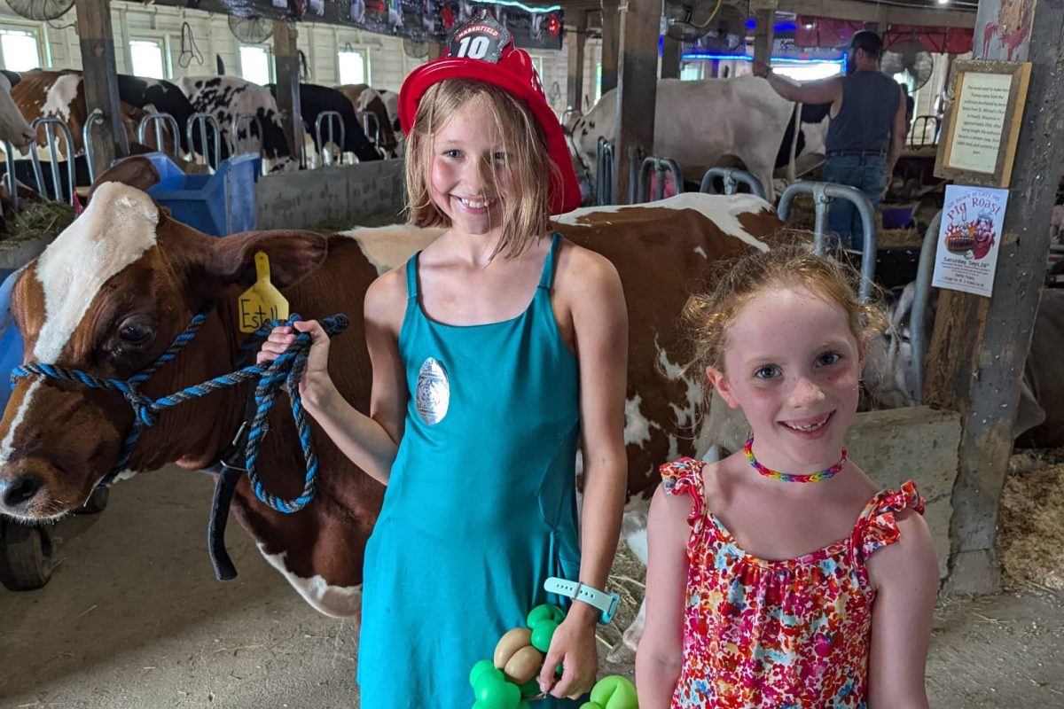 Check out some of central Wisconsin’s best festivals & summer events | Two girls posing with a cow at the Central Wisconsin State Fair in Marshfield
