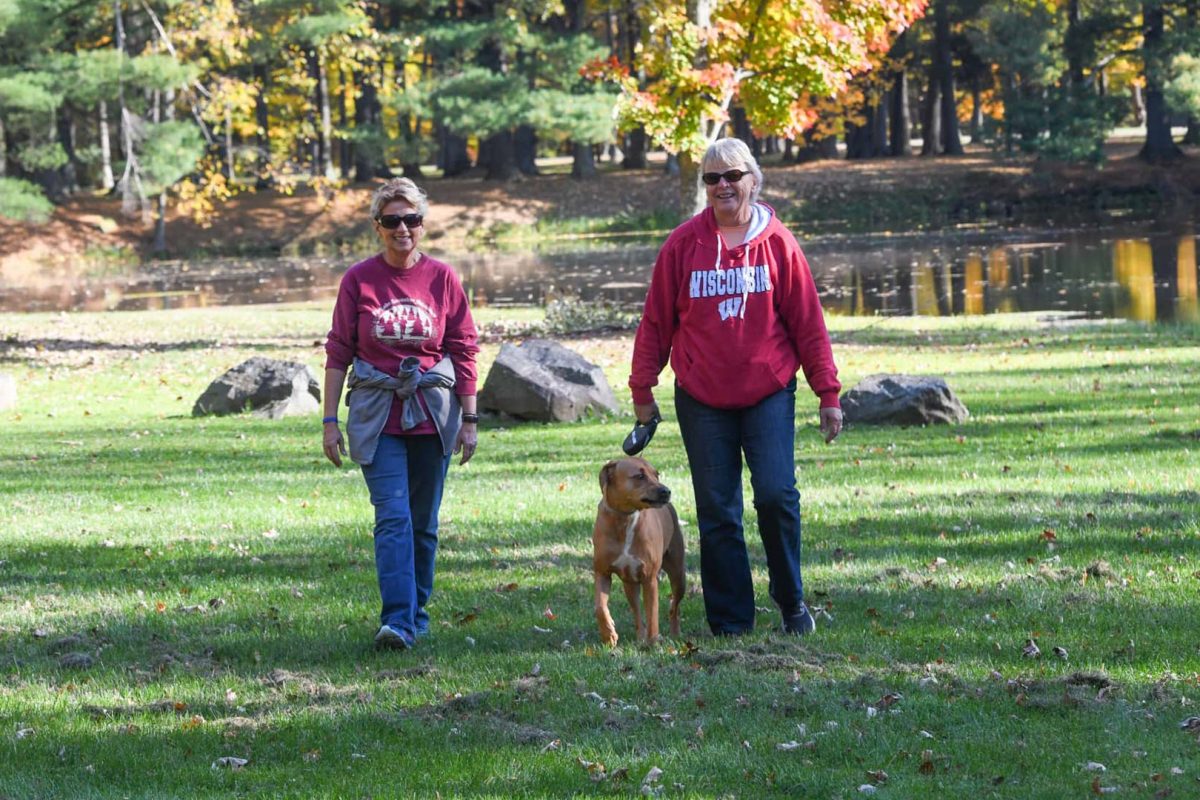 Pet-friendly hotels, restaurants & more in central Wisconsin | Two women walking a dog in fall at North Wood County Park near Marshfield Wisconsin