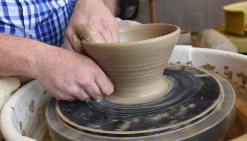 Man sculpting bowl on pottery wheel at Chestnut Center for the Arts in downtown Marshfield Wisconsin