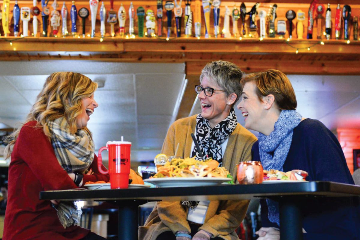 Three women sitting at a table laughing at Nutz Deep II restaurant in downtown Marshfield Wisconsin