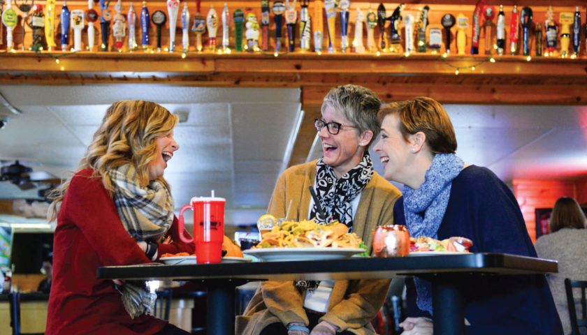 Three women sitting at a table laughing at Nutz Deep II restaurant in downtown Marshfield Wisconsin