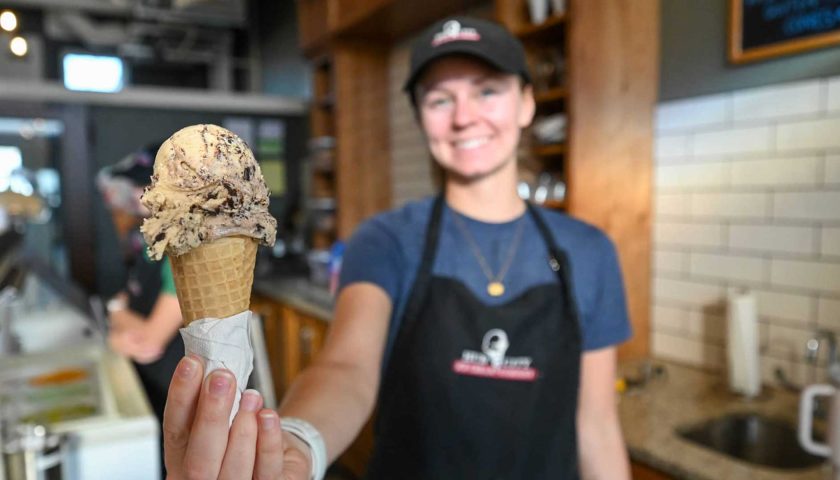 Employee holding ice cream cone up to camera at Hub City Ice Cream in Marshfield Wisconsin